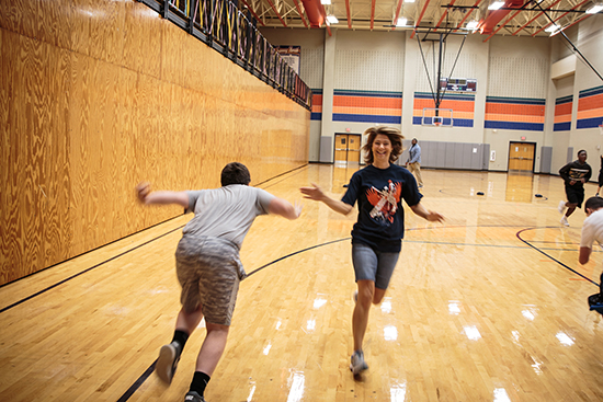 Photo of MISD School Board Secretary Stephanie O'Dell tagging off during a relay in P.E. class.