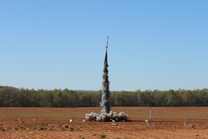 Rocket launching with trail of black smoke.