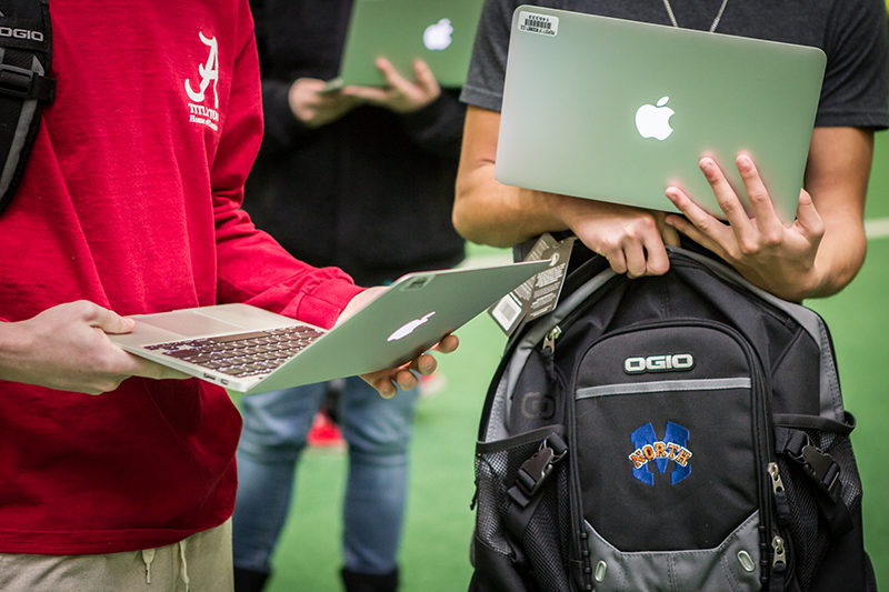 Close up of students holding MacBooks