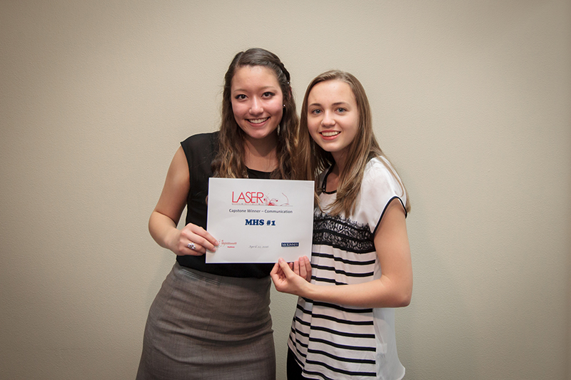 Photo of two female students holding winner certificate