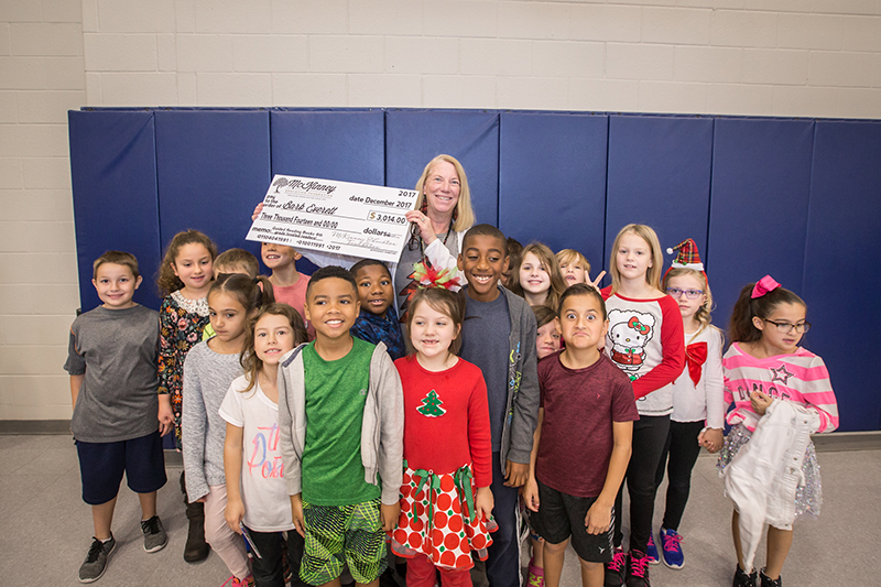 Everett holding big check in the middle of her students