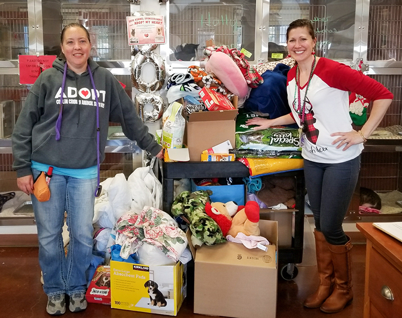 Women standing with pile of donations