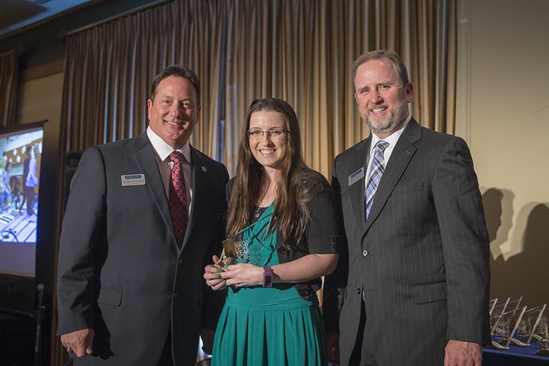 Holding award while standing onstage with McDaniel and Rippee