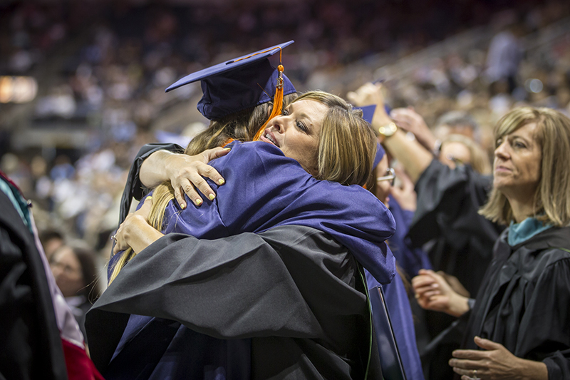 female teacher hugging female graduate after graduate exited the stage