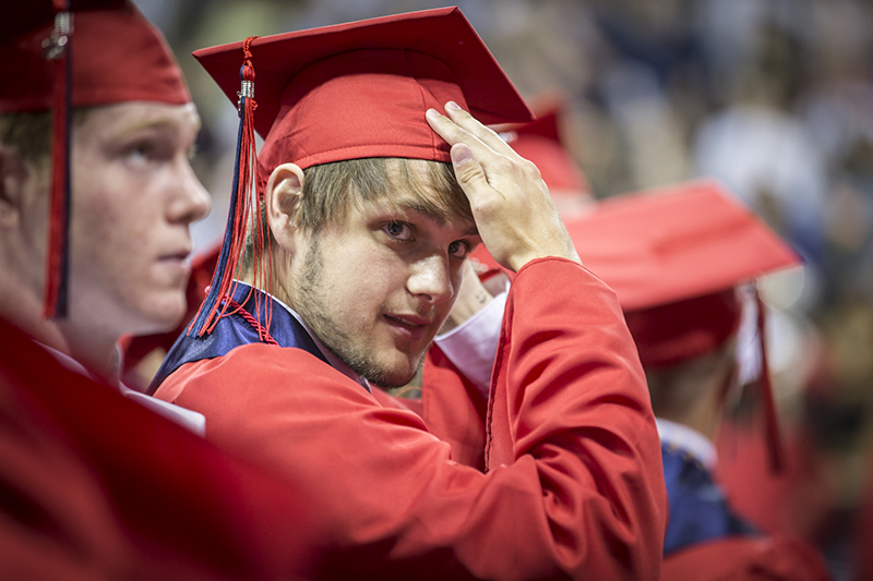 male student adjusts his cap