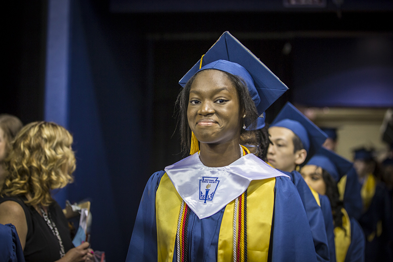 female graduate smiling at camera in line