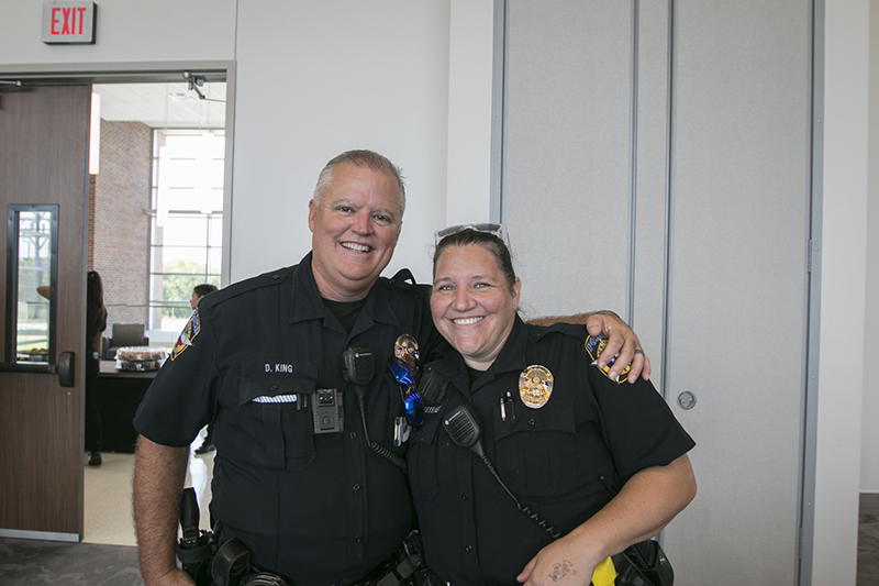 two SROs with arms around shoulders smiling