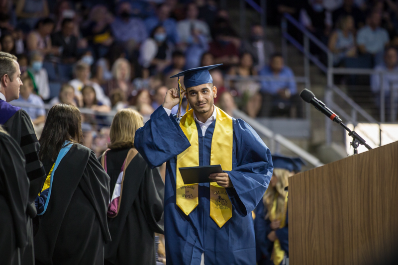 male student crossing the stage