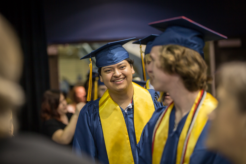 male student smiling at another graduate