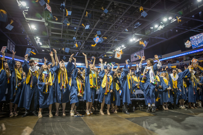 graduates throwing caps into the air