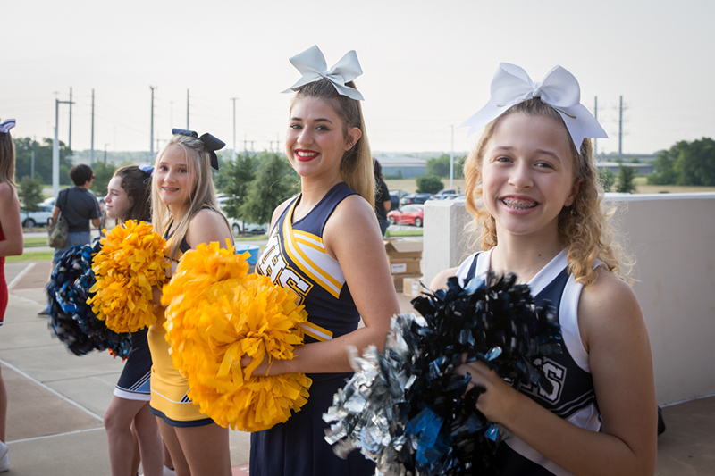 row of middle school cheerleaders smiling at camera