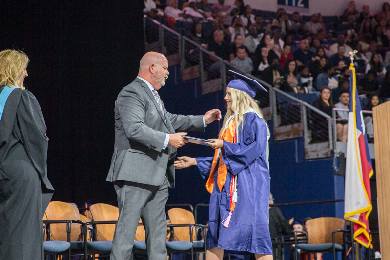 Shawn Pratt handing diploma to daughter onstage