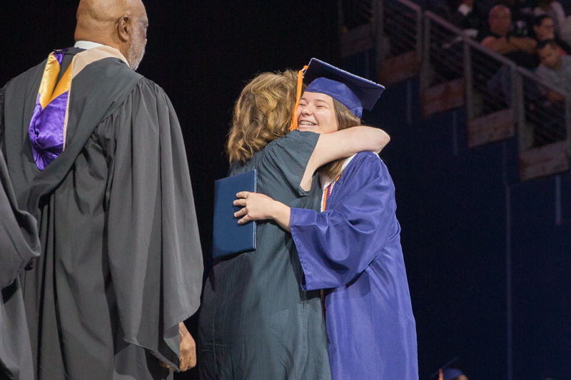 mom hugging daughter grad onstage