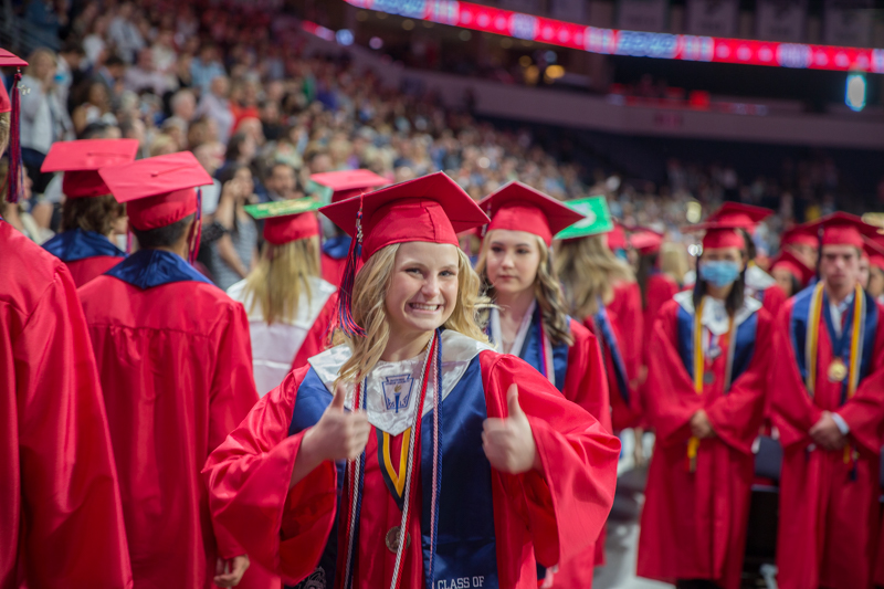 female graduate smiling and giving thumbs up