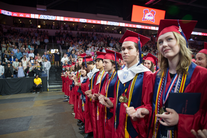 graduates holding pinkies for the alma mater