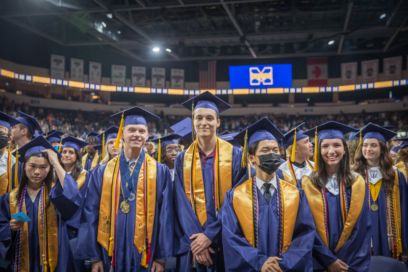 graduates in front row smiling at camera 