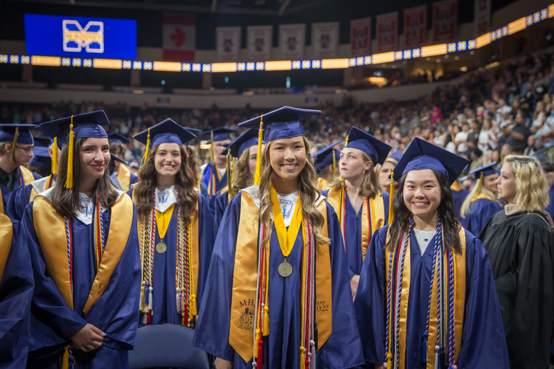 graduates in front row smiling at camera