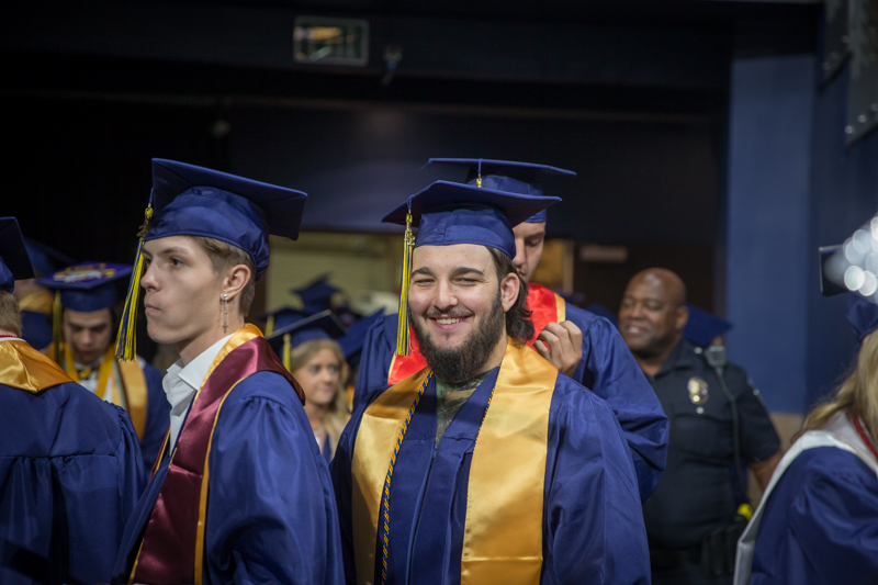 male graduate in line smiling at camera