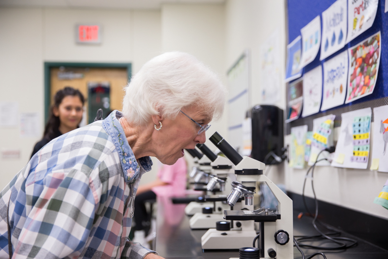 senior adult woman looking in microscope