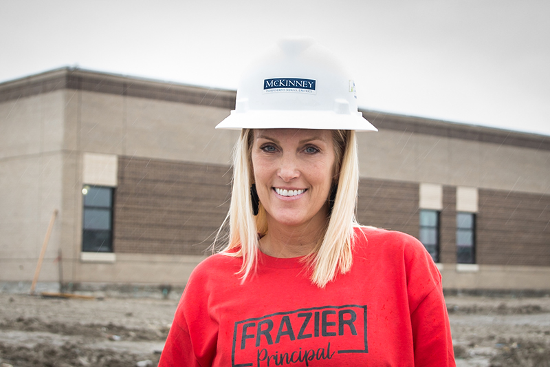 Holderman in front of Frazier construction wearing a hard hat
