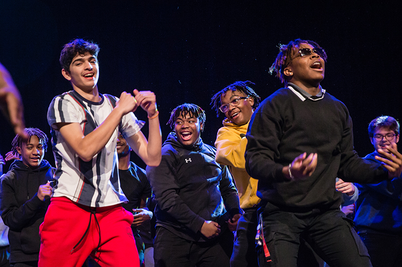 students dancing on stage and smiling