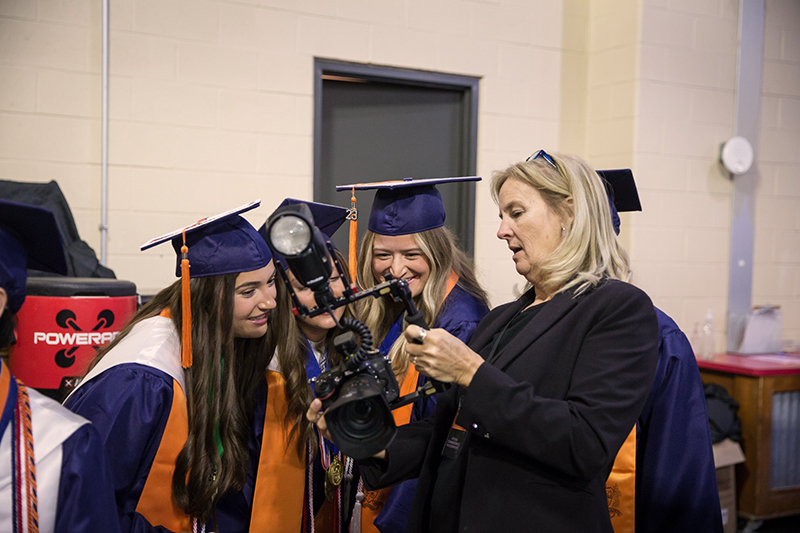 three female students looking at photo on photographers camera