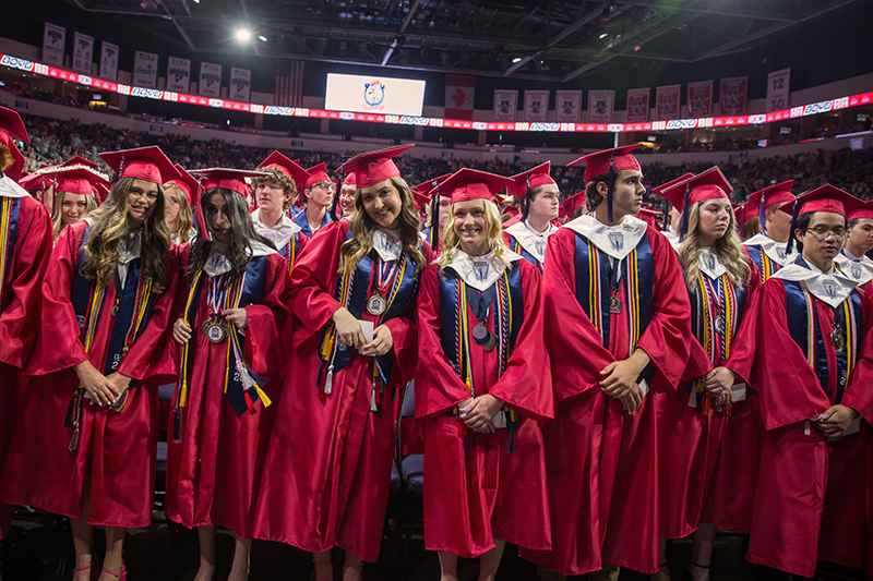 front row of Boyd Graduates, female grads smiling at camera