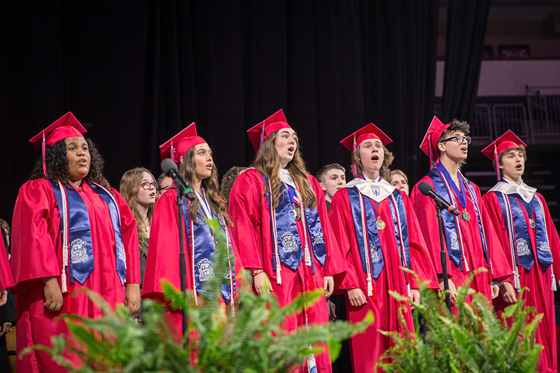 choir members from Boyd in graduation robes on stage singing