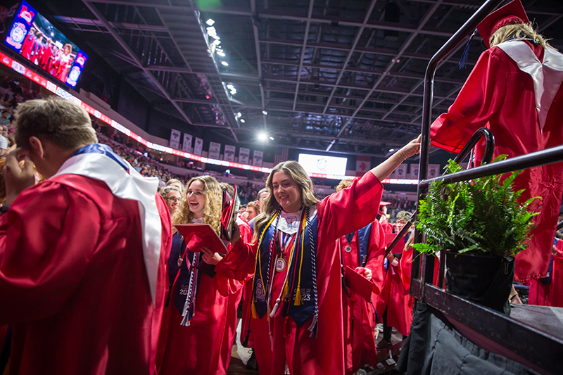 boyd students leaving, female graduate clasping hands with another