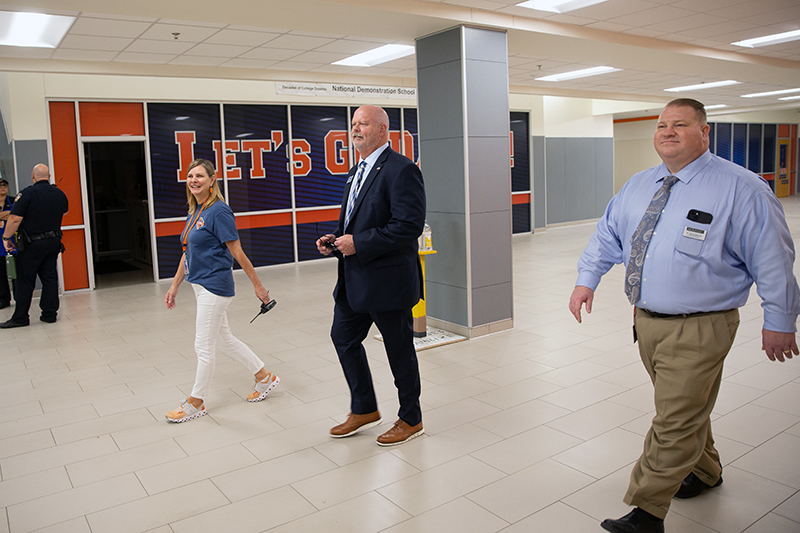 Pratt walking in hallway with principal Jae Gaskell and Dennis Womack, CFO