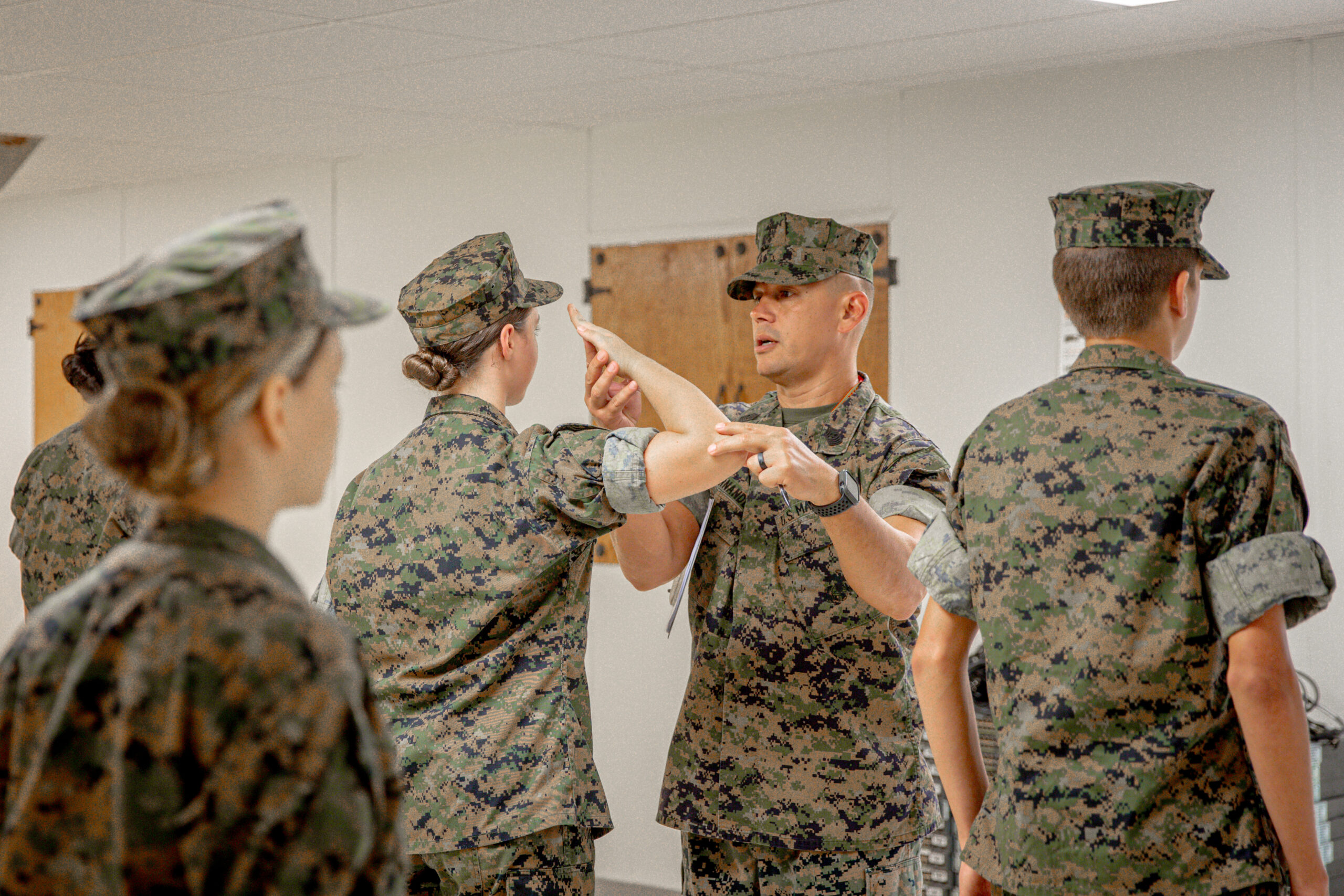 Hernandez moving a cadet's salute into the right position.