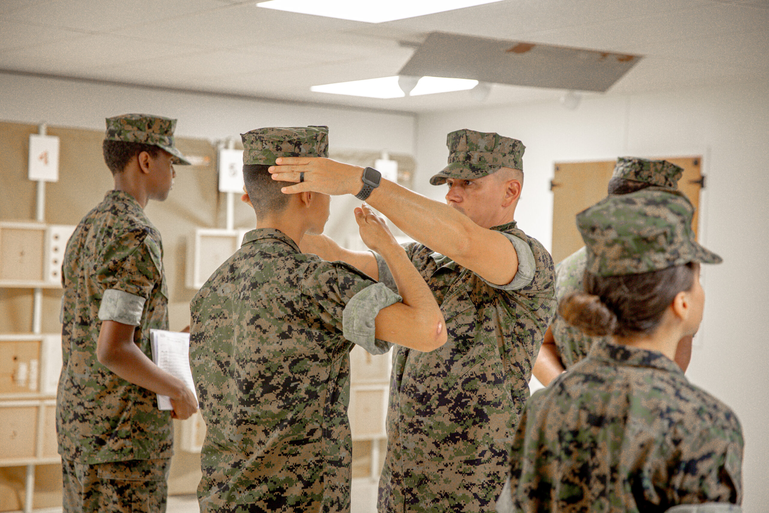 Hernandez adjusting the cover for a cadet during uniform inspection