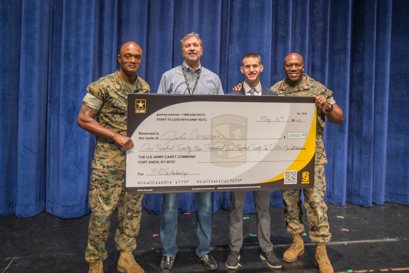 on stage holding oversized check from the US Army