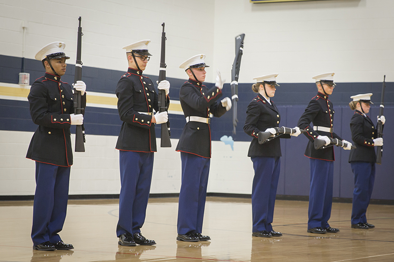 cadets in a line with one twirling rifle