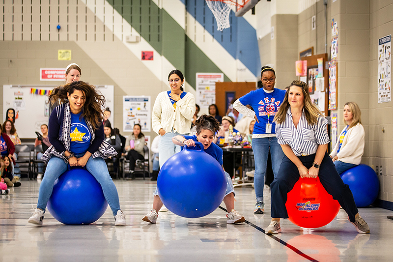teachers on large bounce balls racing and one teacher falling off