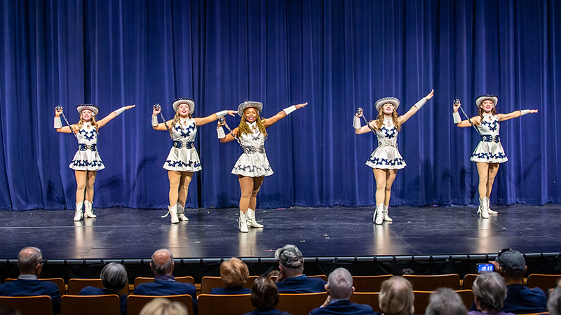 officers of the North drill team perform onstage during a fine arts showcase in full uniform