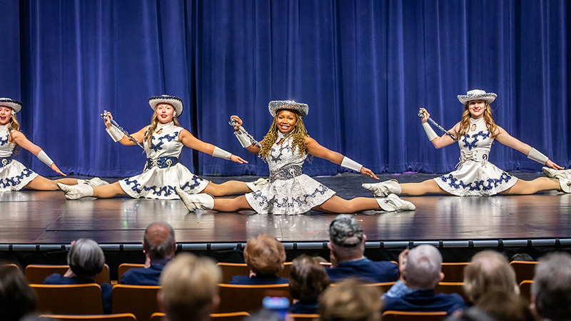officers of the North drill team perform onstage during a fine arts showcase in full uniform