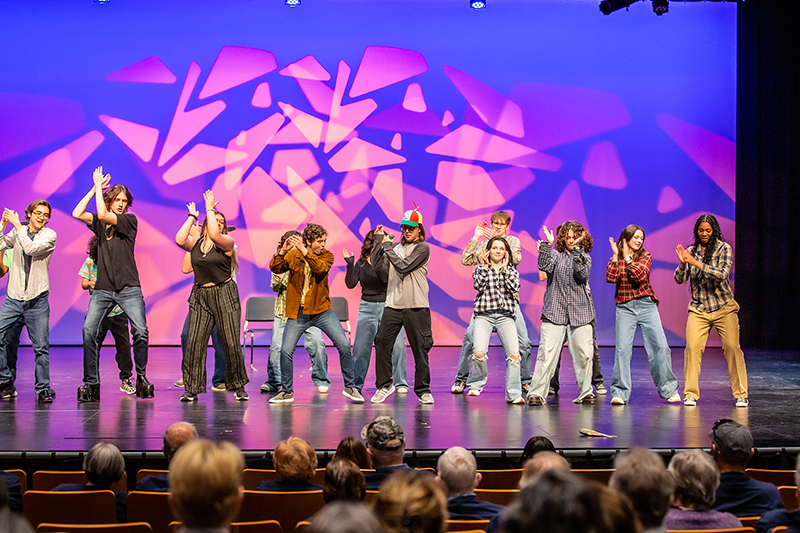 North theater performance continues as whole group performs a song and dance together on stage 